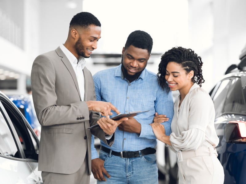 couple looking at a tablet with salesman img